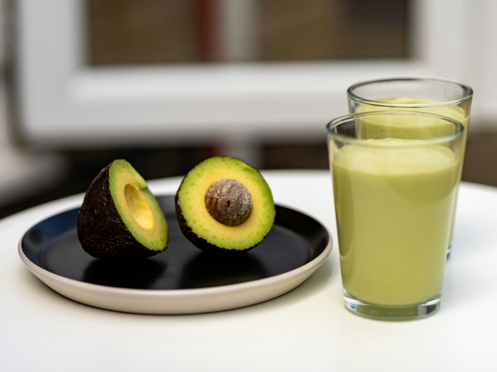 Image showing avacado on a plate and avacado smoothie in a glass